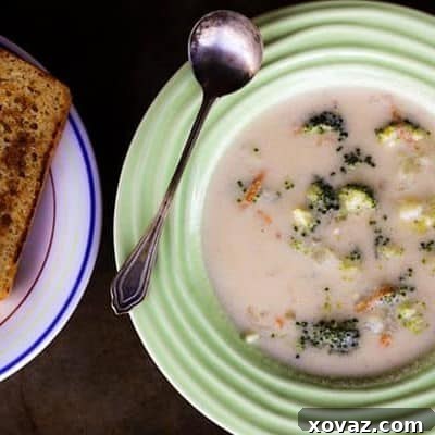 Homemade Broccoli Cheddar Soup in a white bowl with a spoon