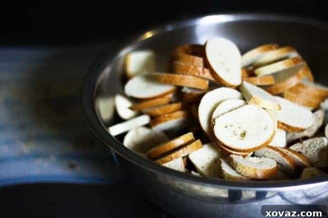 Batch Prep Garlic Bagel Chips for Monday Munchies 3 Preparing homemade garlic bagel chips – thin slices coated in olive oil and seasonings