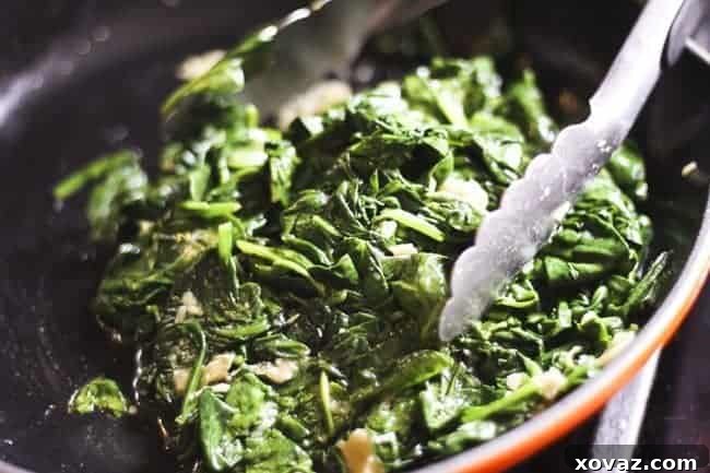 Mediterranean Spinach Feta Turkey Burgers 4 Spinach with garlic for Spinach Feta Turkey Burger – Gently wilted spinach with roasted garlic in a skillet.