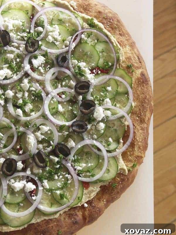 60 Ultimate Game Day Snacks 6 Mediterranean Hummus Pizza, a fresh and vibrant vegetarian appetizer idea.