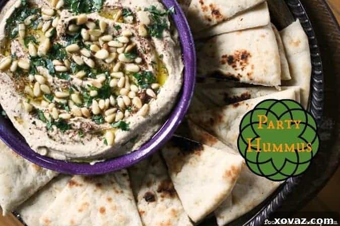 Celebration Hummus 3 Delicious Party Hummus served warm, garnished with fresh parsley and olive oil, capturing the authentic Middle Eastern style.