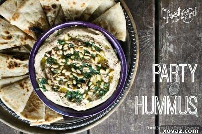 Celebration Hummus 4 Party Hummus with a vibrant topping of fresh parsley, toasted pine nuts, and a dusting of za'atar, highlighting its rich texture.