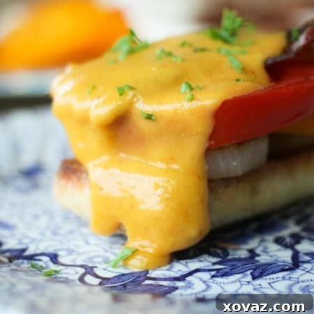 An overhead shot of a single serving of Summer Welsh Rabbit with fried onions, fresh tomato, and crispy bacon.