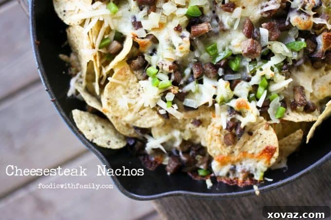 Ultimate Brisket Nachos 3 Cheesesteak Nachos are comfort food deluxe from foodiewithfamily.com cheese, tortilla chips, beef, onions, peppers