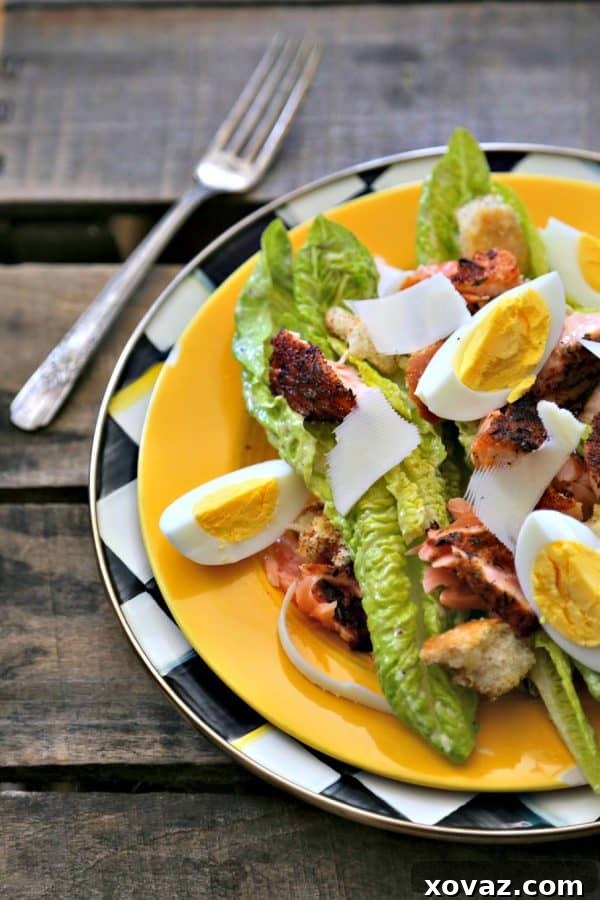Simple, fresh, and filling main dish salad for spring! Blackened Salmon Caesar Salad with torn croutons, hard boiled egg, homemade dressing, and flaked blackened salmon gives the traditional Caesar salad a flavourful facelift!