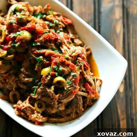 Slow Cooker Italian Shredded Beef full of sun dried tomatoes, wine, garlic, fire roasted tomatoes, olives, and capers