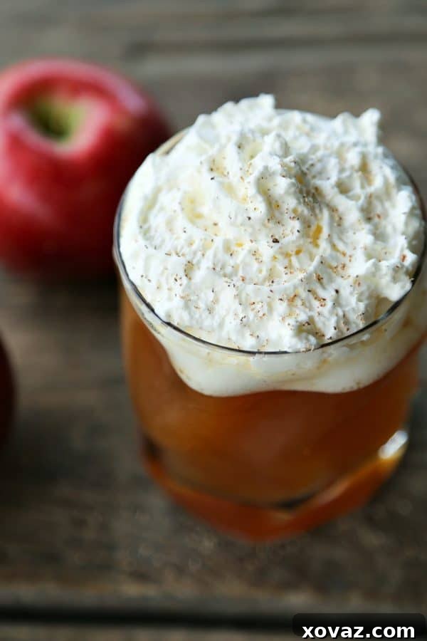 Hot Maple Bourbon Apple Cider from foodiewithfamily.com, garnished with whipped cream and a sprinkle of nutmeg