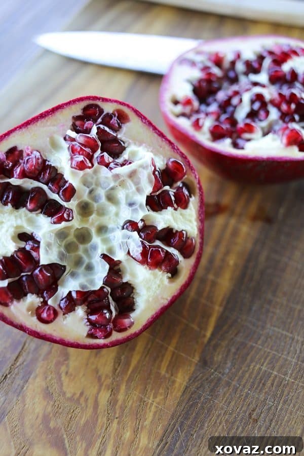 The easiest method by far; How to Deseed a Pomegranate in 1 Minute flat! A vibrant pomegranate cut in half, revealing juicy arils.