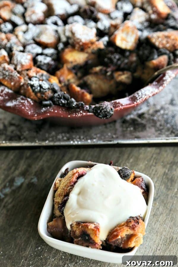 A close-up of a serving of Chocolate Cherry Doughnut Bread Pudding showing the creamy texture and melted chocolate chunks.