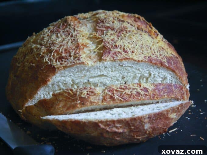 Asiago Herb and Garlic Bread - Freshly Baked asiagoherbbread-19 - A golden-brown loaf of Asiago Herb and Garlic Bread, freshly baked with a cheesy crust.