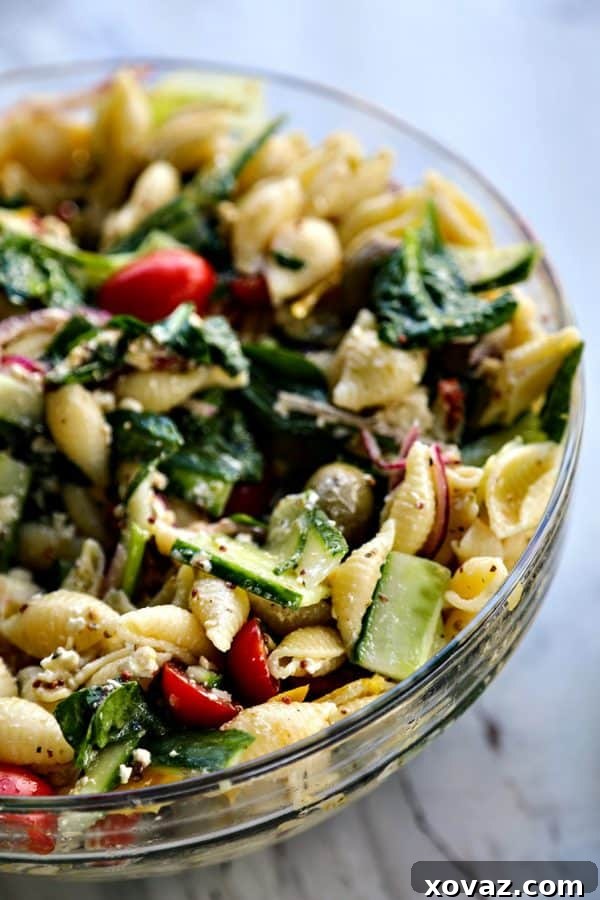 Garden Fresh Greek Pasta Salad 3 Close-up of fresh ingredients for Greek Pasta Salad, including vibrant bell peppers, cherry tomatoes, and various Greek olives, ready to be mixed.