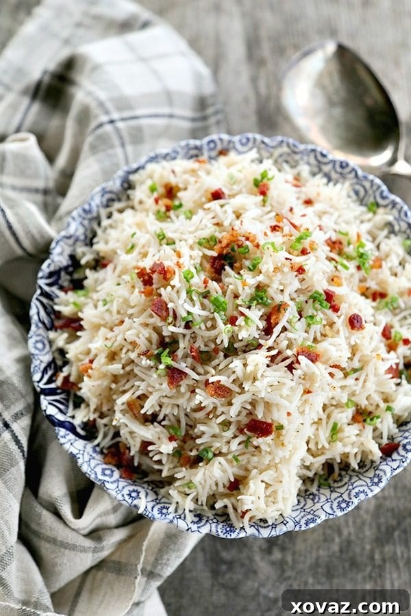 Close-up of fluffy Bacon Garlic Rice, showing individual grains, crispy bacon bits, and chopped green onions, ready to serve.