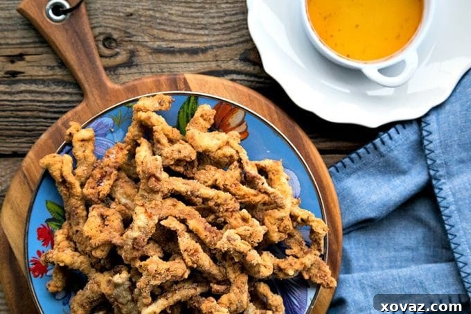 A vibrant platter of golden-brown Crispy Pork Tenders, perfectly fried and ready to be served, making them an ideal party or game day snack.