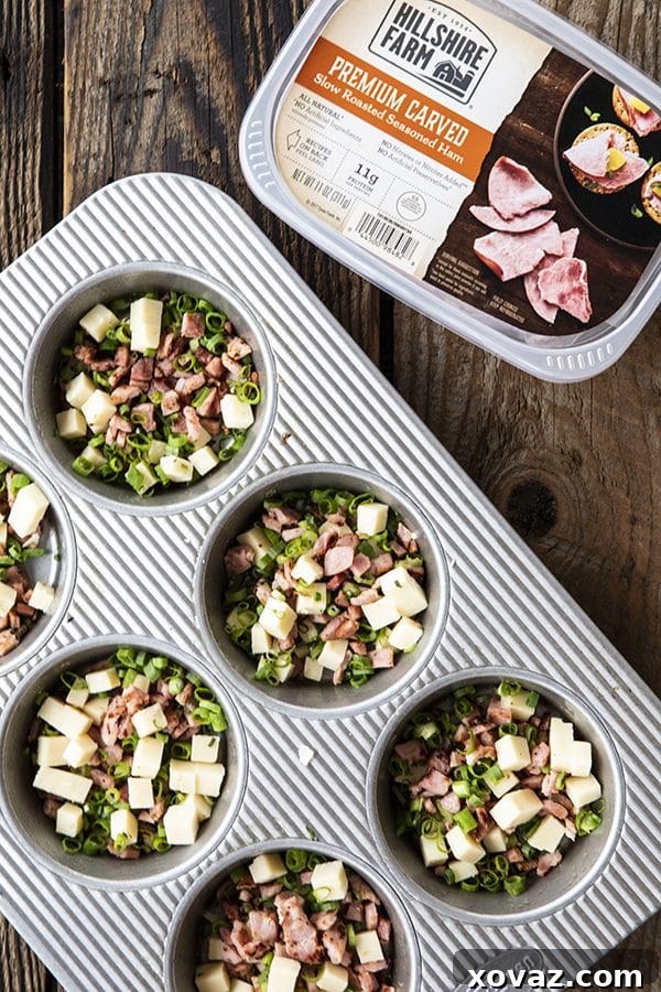 Baked Egg Bites 4 A tray of Muffin Tin Eggs with ham, green onions, and cheddar, fresh from the oven, offering a convenient and delicious make-ahead breakfast option.