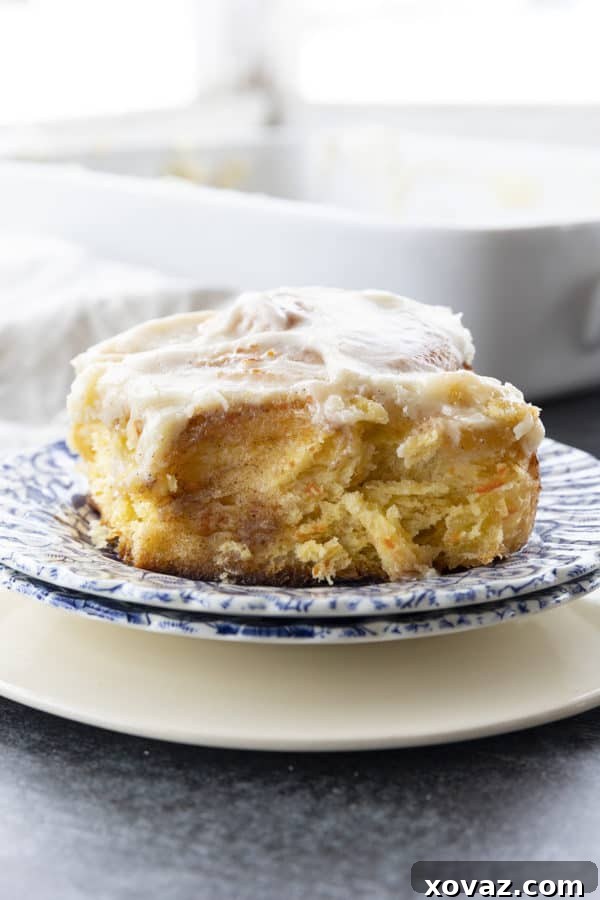 Large, fluffy Carrot Cake Cinnamon Rolls generously topped with orange vanilla cream cheese icing, studded with finely shredded carrots and a spiced buttery brown sugar filling.