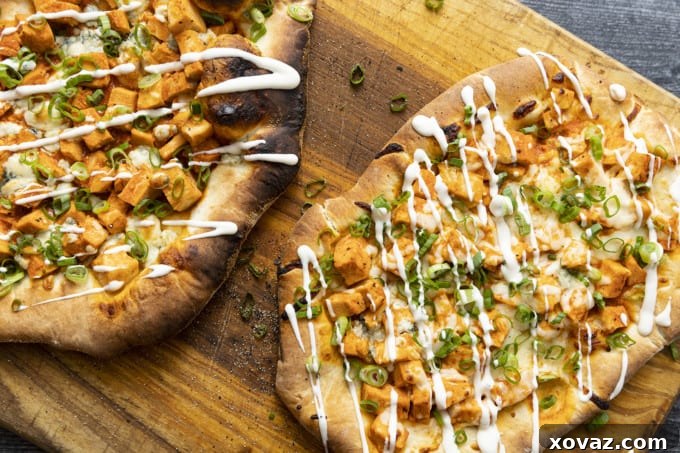 Bold Buffalo Chicken Flatbread 4 The cooking process of Buffalo Chicken Flatbread inside an Ooni pizza oven, showing its crispy edges.