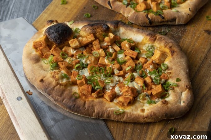Bold Buffalo Chicken Flatbread 7 A Buffalo Chicken Flatbread being garnished with fresh green onions and dressing.