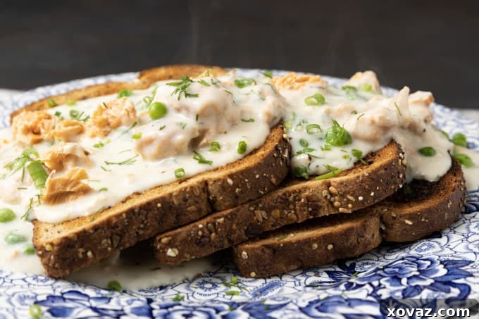 Fresh lemon wedges, dried dill, and a bowl of green peas, key ingredients to enhance the creamed salmon.