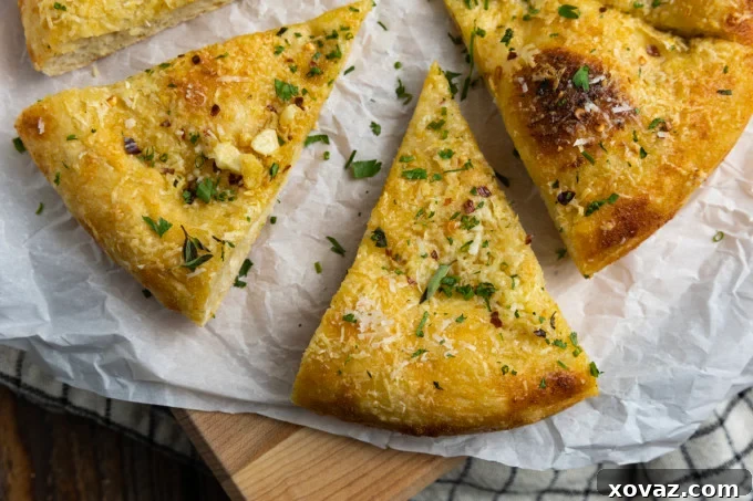 Ultimate Garlic Pizza 3 Close-up of a bubbling garlic pizza, golden brown with a crispy crust, showing the melted Parmesan cheese and minced garlic, ready to be garnished with fresh herbs.