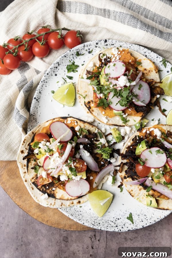 Crispy seasoned mushrooms roasting on a sheet pan for vibrant meatless tacos.