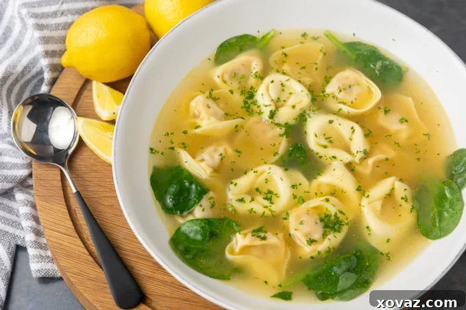A bowl of Tortellini in Brodo garnished with fresh parsley.
