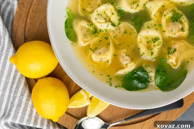 A large pot of chicken stock simmering with lemon zest and garlic.
