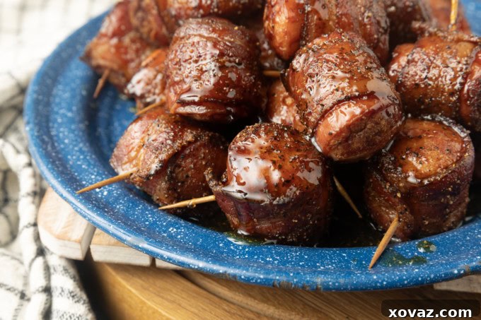 Crispy Air Fryer Kielbasa 2 Crispy air fryer kielbasa bites wrapped with bacon, drizzled with honey, served on a blue plate