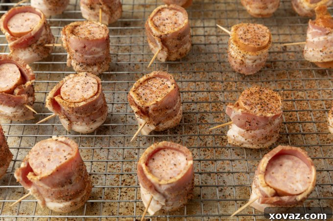 Crispy Air Fryer Kielbasa 6 Seasoned kielbasa in air fryer bites wrapped with bacon on a cooling rack, ready to cook