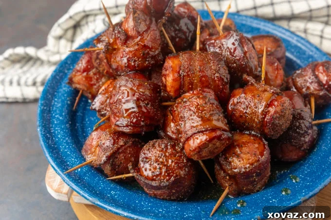 Crispy Air Fryer Kielbasa 7 Air fryer kielbasa bites wrapped with bacon drizzled with honey on a blue plate, close up