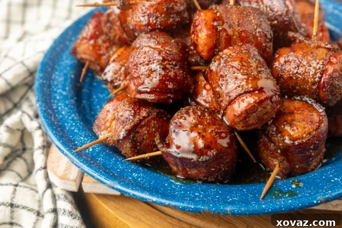 Crispy Air Fryer Kielbasa 9 Air fryer kielbasa bites wrapped with bacon drizzled with honey on a blue plate, served and ready to eat
