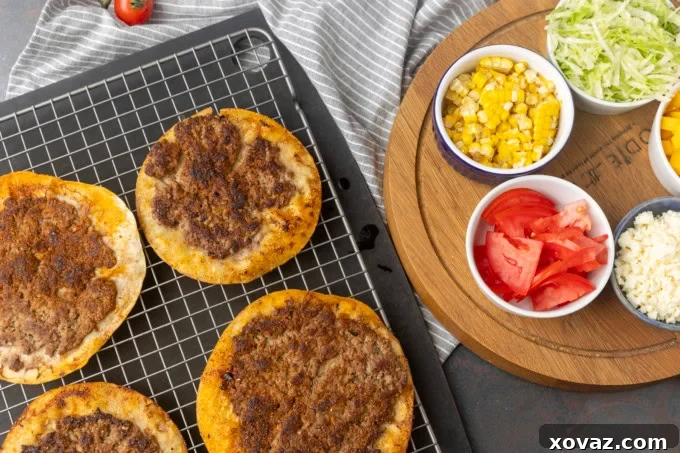 Crispy Smash Tacos 4 Freshly cooked smash tacos cooling on a wire rack, with vibrant topping bowls blurred in the background.