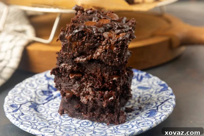 Decadent Greek yogurt brownies artfully arranged on a pristine white plate, showcasing their rich, fudgy texture and dark chocolate sheen. Perfect for an eggless dessert.
