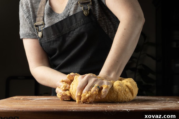 Mastering Fresh Pasta from Scratch 9 Thin sheet of pasta dough coming out of a machine.