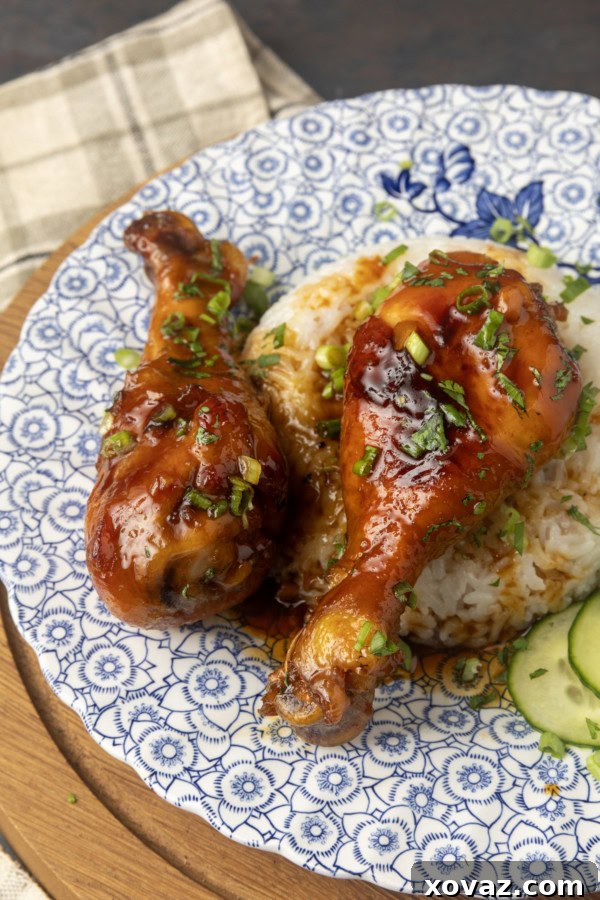 Honey-Glazed Garlic Chicken 6 baked honey garlic chicken on rice with cucumbers on a blue and white plate