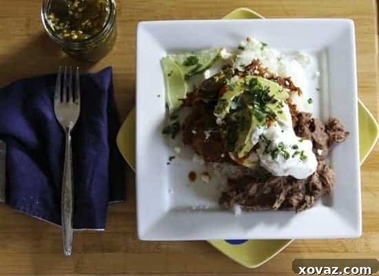 A closer view of the Hot TexMess, showing the rich salsa, tender meat, and golden fried eggs.
