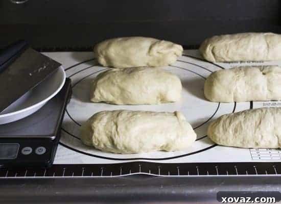 Dough divided into equal logs, resting on a work surface, ready for further shaping.