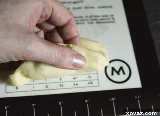 Dough being rolled up around the central indentation to form the initial bun shape.