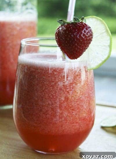 Freshly blended Strawberry Limeade ready for serving, in a clear glass pitcher.