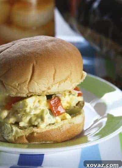 Delicious egg and olive salad sandwich on a soft roll, garnished with fresh dill.