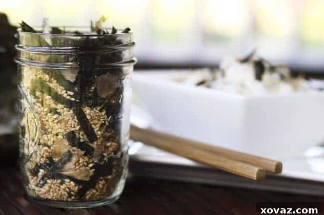 A jar of freshly made Homemade Furikake next to ingredients like nori and sesame seeds.