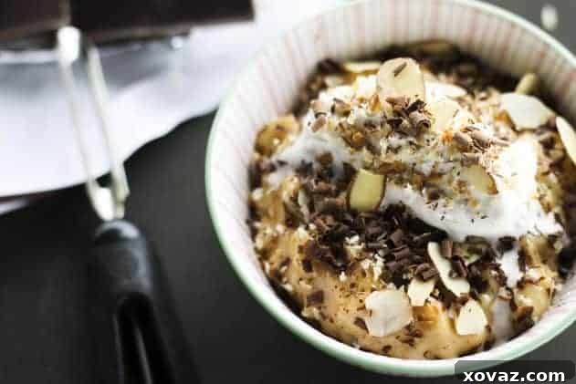 Mounds Bar Rice Pudding - A Coconut and Dark Chocolate Delight Delicious Mounds Bar Rice Pudding served in a bowl, garnished with toasted coconut, dark chocolate shavings, and whipped coconut cream.