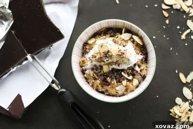 Mounds Bar Rice Pudding - Closer Look Mounds Bar Rice Pudding in a bowl, with a spoon ready to serve. Topped with whipped coconut cream and chocolate shavings.