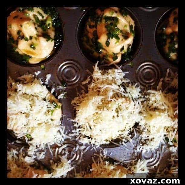 Cheese Topping for Mini Cheddar Scallion Monkey Breads Close-up of shredded cheddar cheese covering raw monkey bread dough in a muffin tin