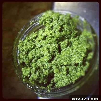 Freshly made arugula and walnut pesto in a bowl, vibrant green and rich.