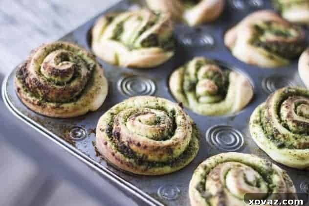 Pesto Pinwheel Rolls baked in muffin tins, showing distinct, tall swirls.