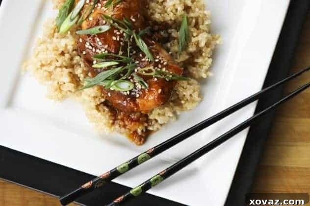 Close-up of Slow Cooker Honey Sesame Chicken in a bowl, garnished with green onions.