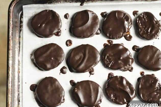 moundsandalmondjoycookies10 A tray of freshly made Almond Joy and Mounds cookies, featuring glossy chocolate tops and visible coconut and almond layers, ready to be enjoyed.