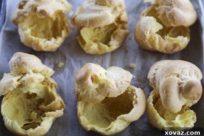 A batch of homemade cream puffs, perfect for filling, alongside a valuable tip on freezing choux pastry dough for instant desserts.