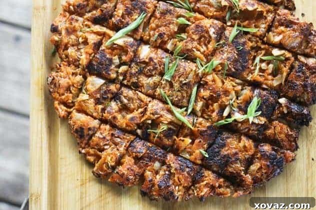 Crispy Kimchi Pancake (Kimchijeon) on a wooden cutting board, garnished with green onions and ready to be served.