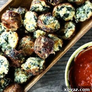 Cheesy Spinach Puffs in a wooden serving dish with marinara sauce